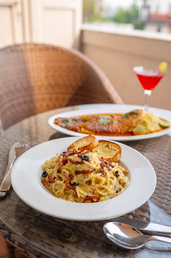 Creamy pasta dish with garlic bread and mocktail