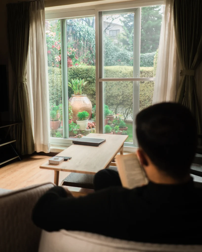 guest reading with green garden view at Shaligram wellness hotel in Kathmandu